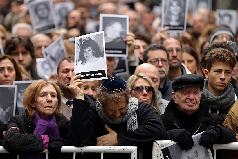 אנשים נושאים את תמונות ההרוגים בפיגוע בבואנוס איירס
