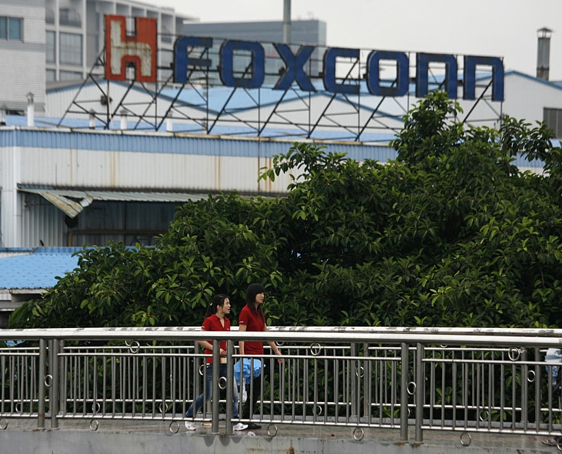 Foxconn Workers Walk On A Footbridge Outside A Foxconn Factory Building In The Township Of Longhua