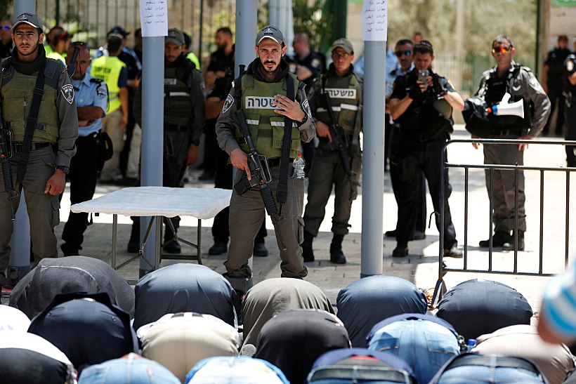מוסלמים מתפללים מול שוטר מג