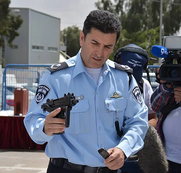 ניצב יורם הלוי עם כלי נשק המוחזקים שלא כחוק שתפסה המשטרה במחוז הדרומי