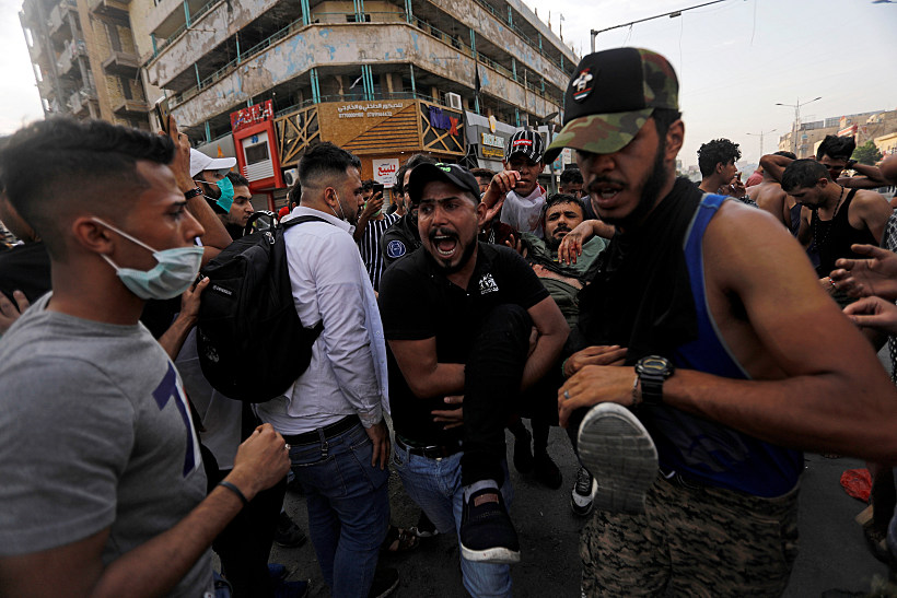 Men Carry Away A Protester Injured During A Protest Against Government Corruption Amid Dissatisfaction At Lack Of Jobs And Services At Tahrir Square In Baghdad