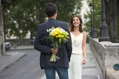 פגישה ברחוב כשהגבר מביא פרחים