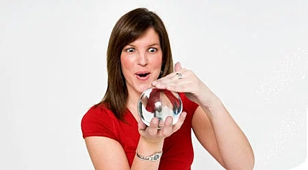 אישה בחולצה אדומה מחזיקה ומתבוננת בכדור בדולח