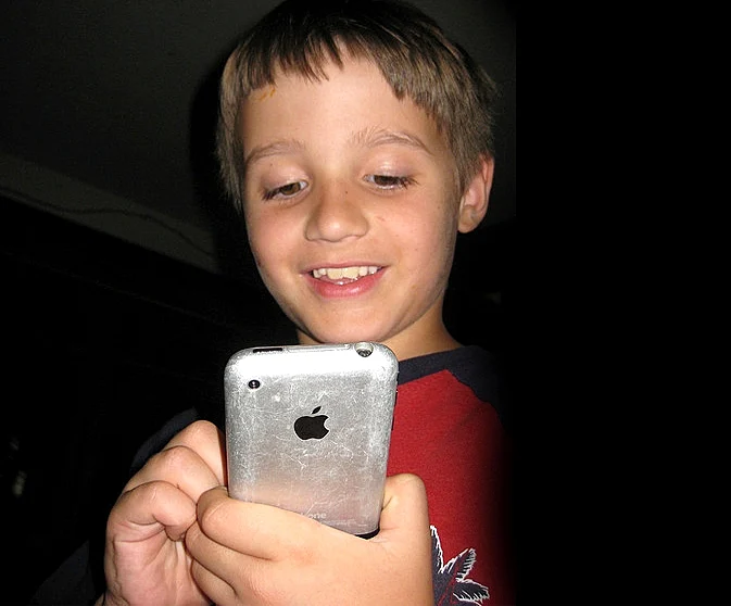 ילד משחק באייפון