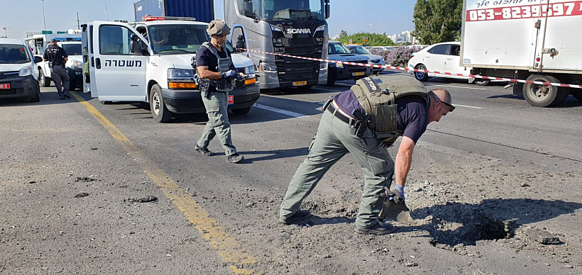 שוטרי משטרת ישראל מפנים חלקי רקטה שנחתו בשטח ישראל