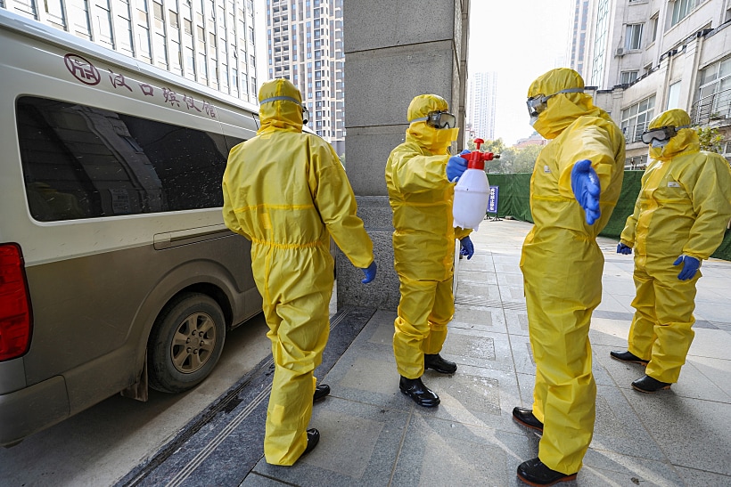 Funeral Parlour Staff Members In Protective Suits Help A Colleague With Disinfection After They Transferred A Body At A Hospital, Following The Outbreak Of A New Coronavirus In Wuhan