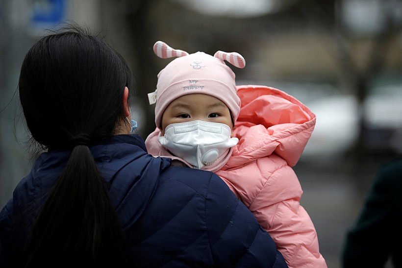 תינוקת עם מסיכה בסין
