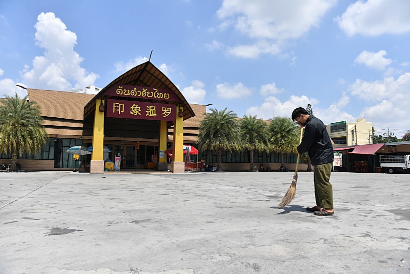 מנקה רחובות מחוץ למקדש בבנגקוק תאילנד