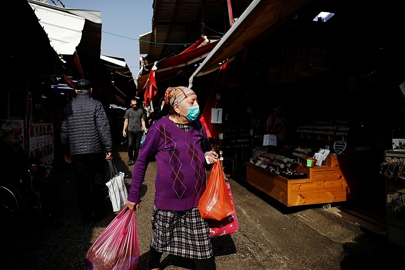 אישה הלובשת מסיכת פנים בשוק בתל אביב