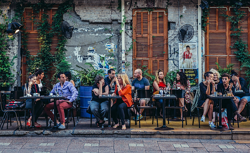 אנשים יושבים בבית קפה תל אביבי
