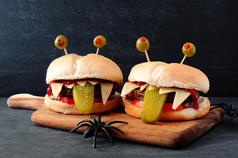 Halloween,monster,hamburgers,on,a,paddle,board,against,a,black