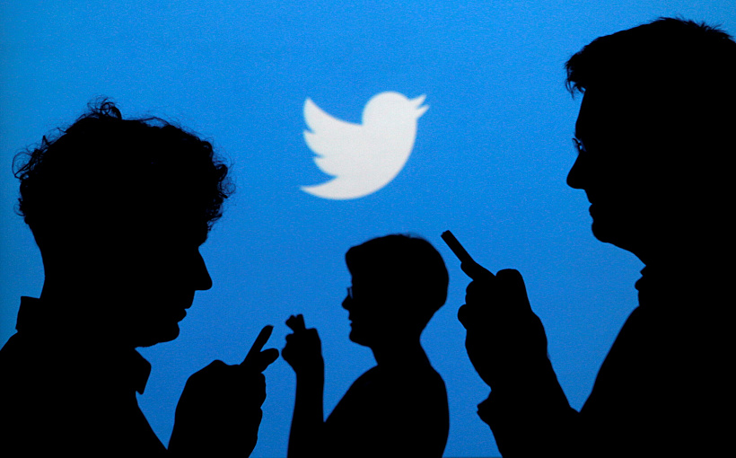 File Photo: People Holding Mobile Phones Are Silhouetted Against A Backdrop Projected With The Twitter Logo In Warsaw