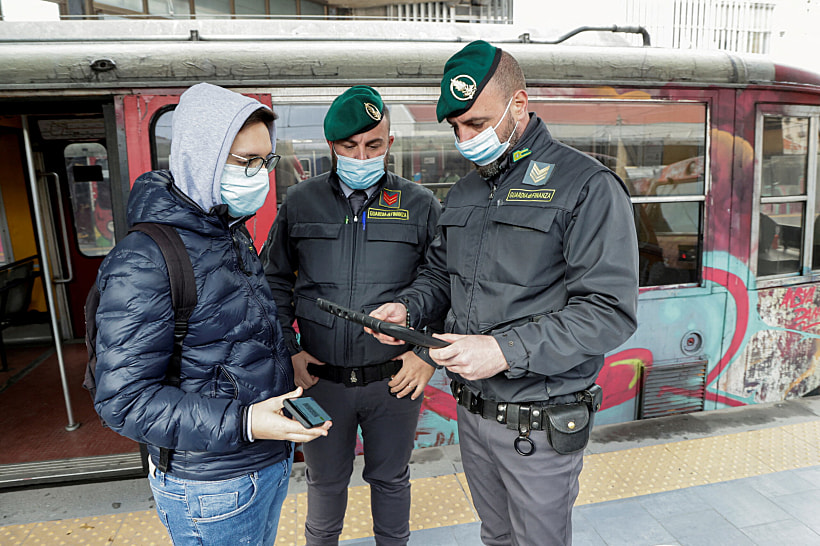 שוטרים בודקים תו ירוק בתחנת רכבת בנאפולי שבאיטליה