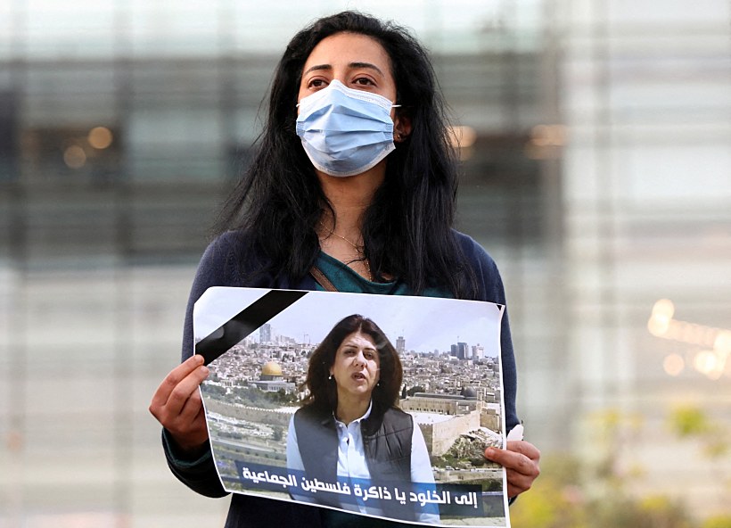 עיתונאית לבנונית מחזיקה תמונה של שירין אבו עאקלה מול בניין האו''ם בביירות