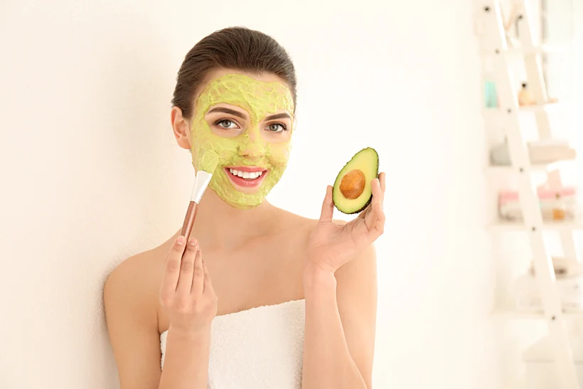 Beautiful,young,woman,applying,avocado,facial,mask,in,bathroom