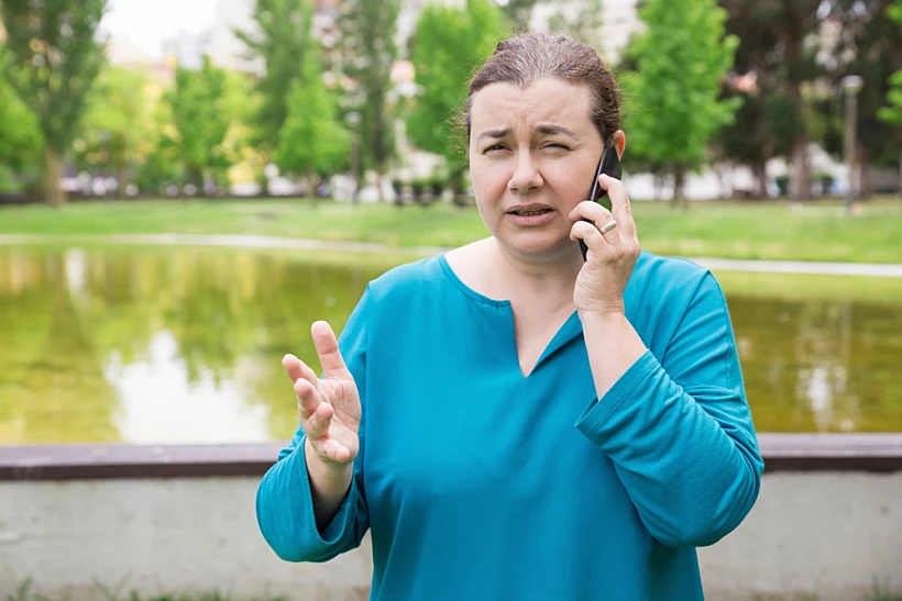 אשה מודאגת מדברת בטלפון בחוץ