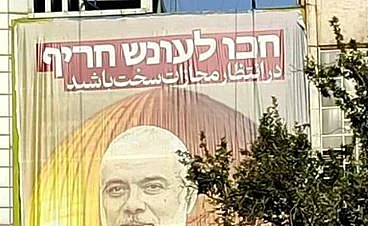 כרזה של הנייה בלב טהרן, עם כיתוב בעברית: "חכו לעונש חריף"