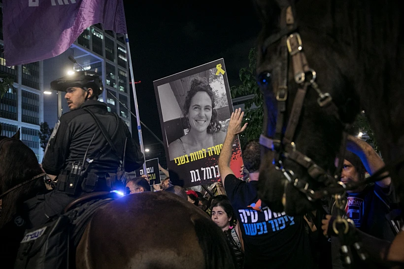 שלט עם תמונתה של כרמל גת בהפגנה בתל אביב