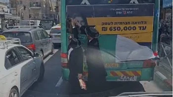 תיעוד: עוברי אורח תולשים שלט עם פני אישה מאוטובוס בירושלים