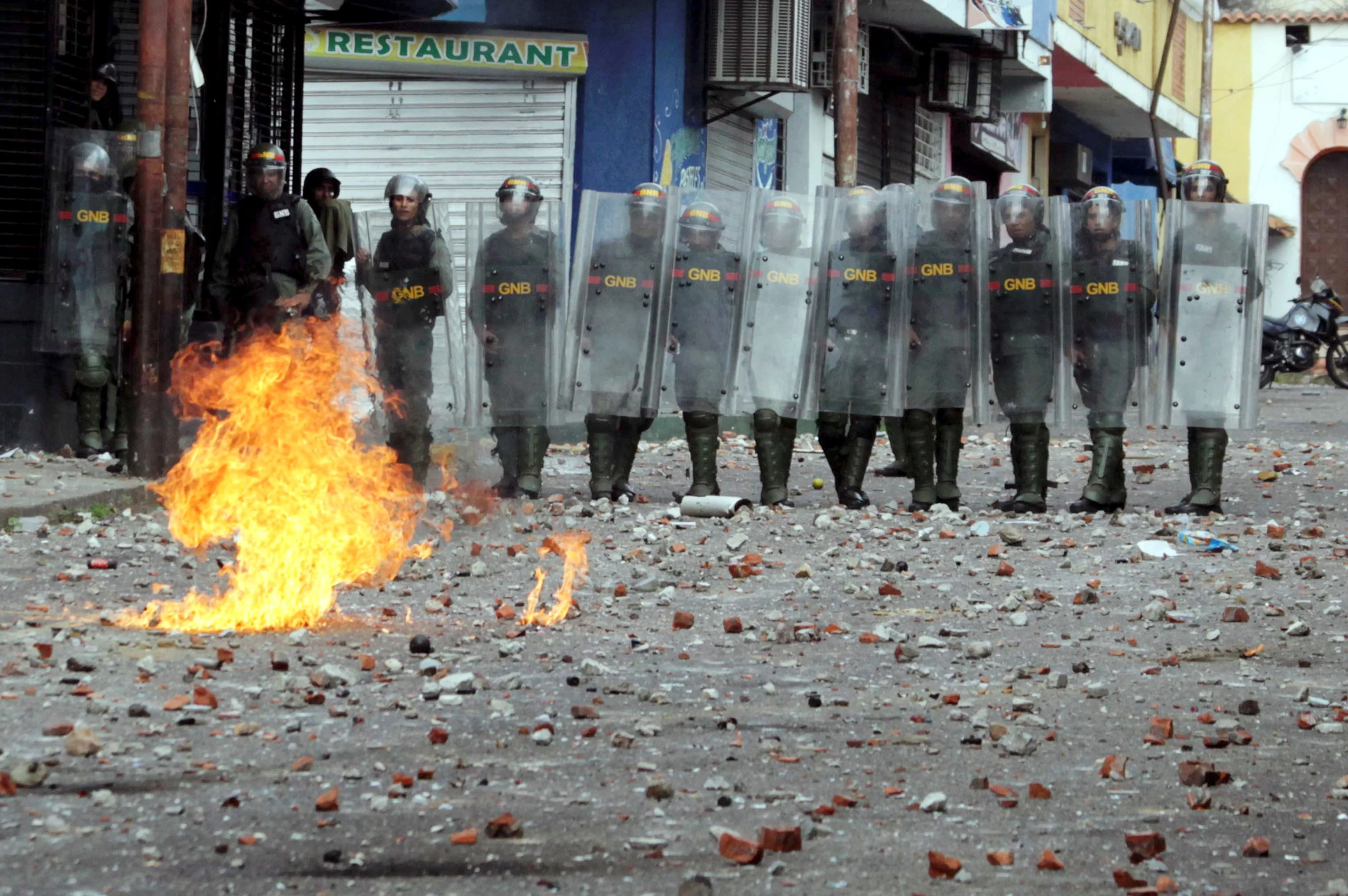 שוטרים ניצבים מול מפגינים במהלך עימותים בוונצואלה