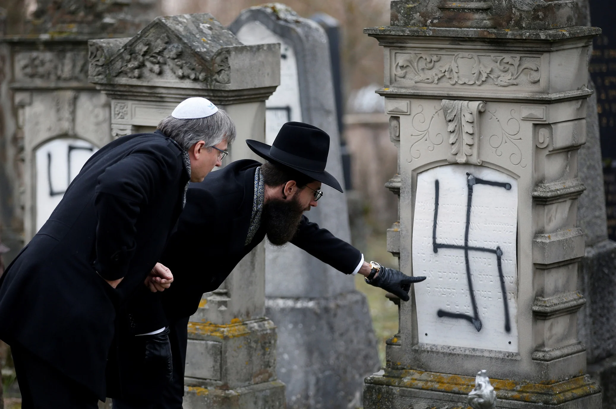 הרב הראשי בשטרסבורג בוחן את הכתובות האנטישמיות שרוססו על מצבות בבית הקברות היהודי