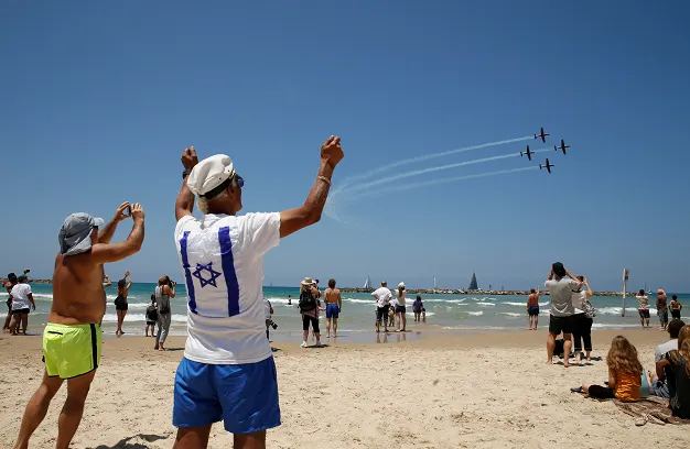 אנשים בחוף היום צופים במטס חיל האוויר ביום העצמאות