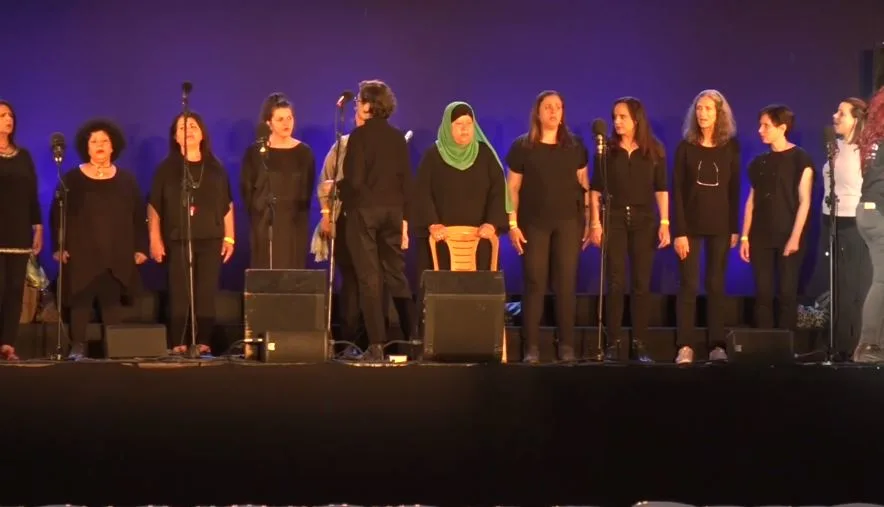להקה של יהודיות ופלסטינאיות שרות שיר על הבמה בטקס יום הזיכרון הישראלי-פלסטיני