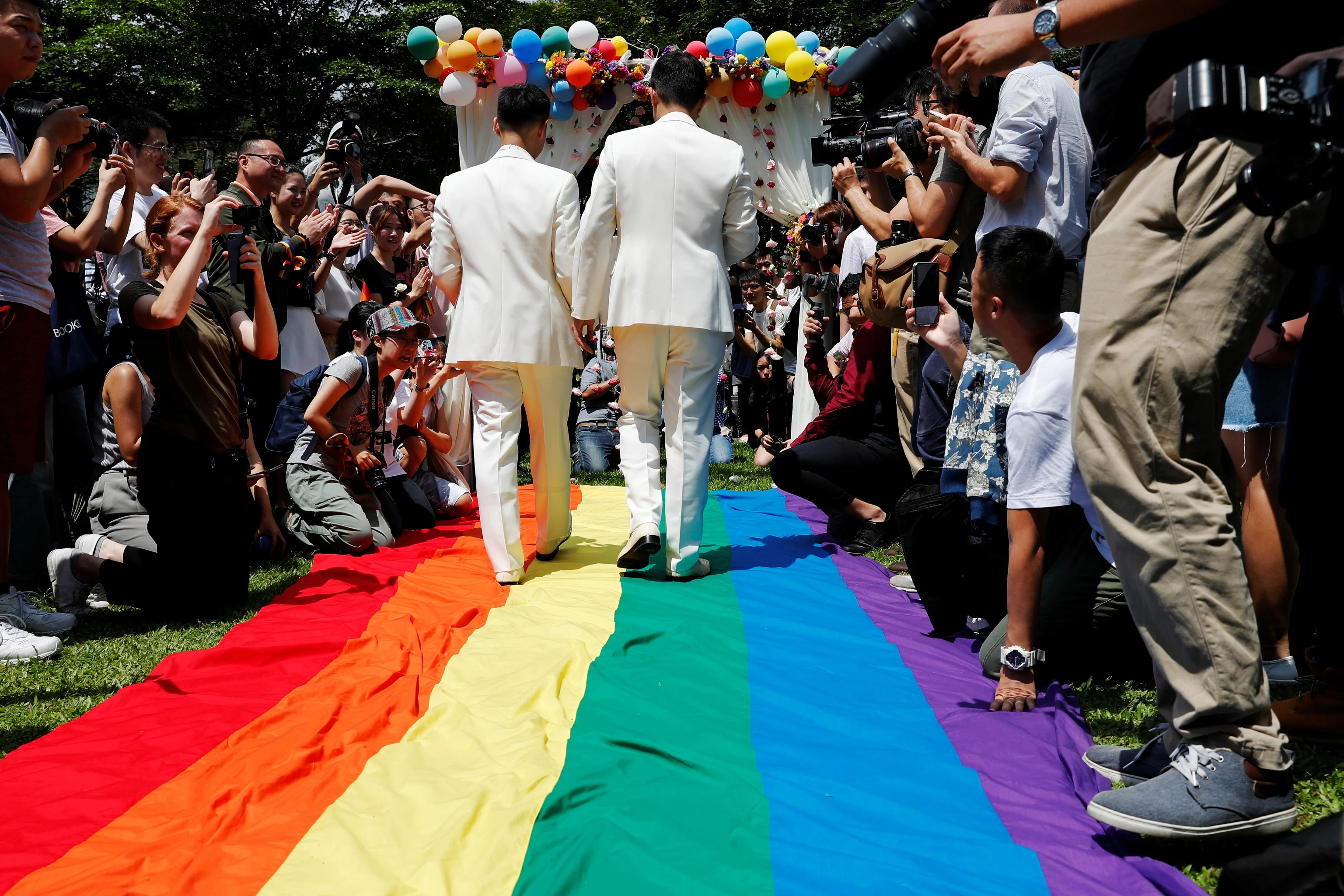 Gay Newlyweds Walk On A Giant Rainbow Flag At A Pro Same Sex Marriage Party After Registering Their Marriage In Taipei