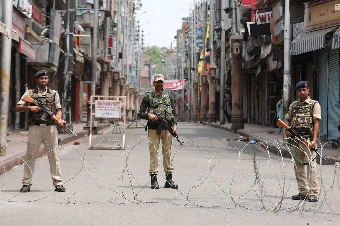 Indian Security Personnel Stand Guard Along A Deserted Street During Restrictions In Jammu