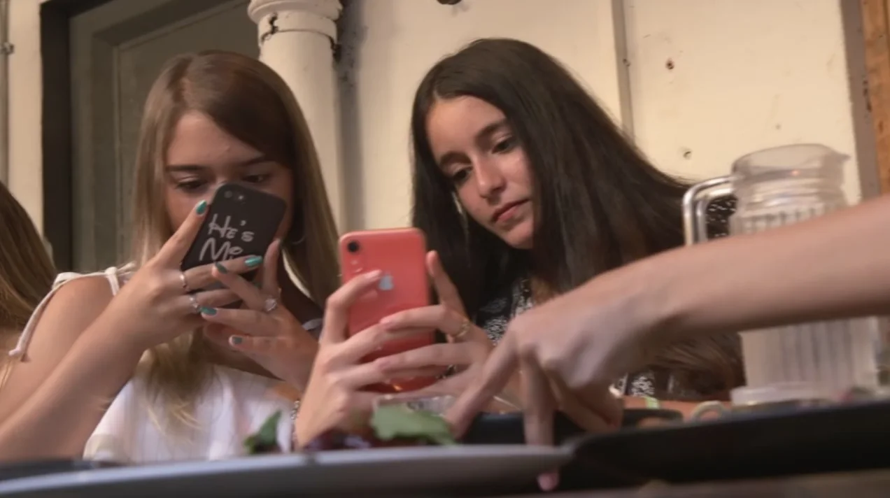 צעירות מצלמות את המנות שלהן באמצעות הסמארטפון