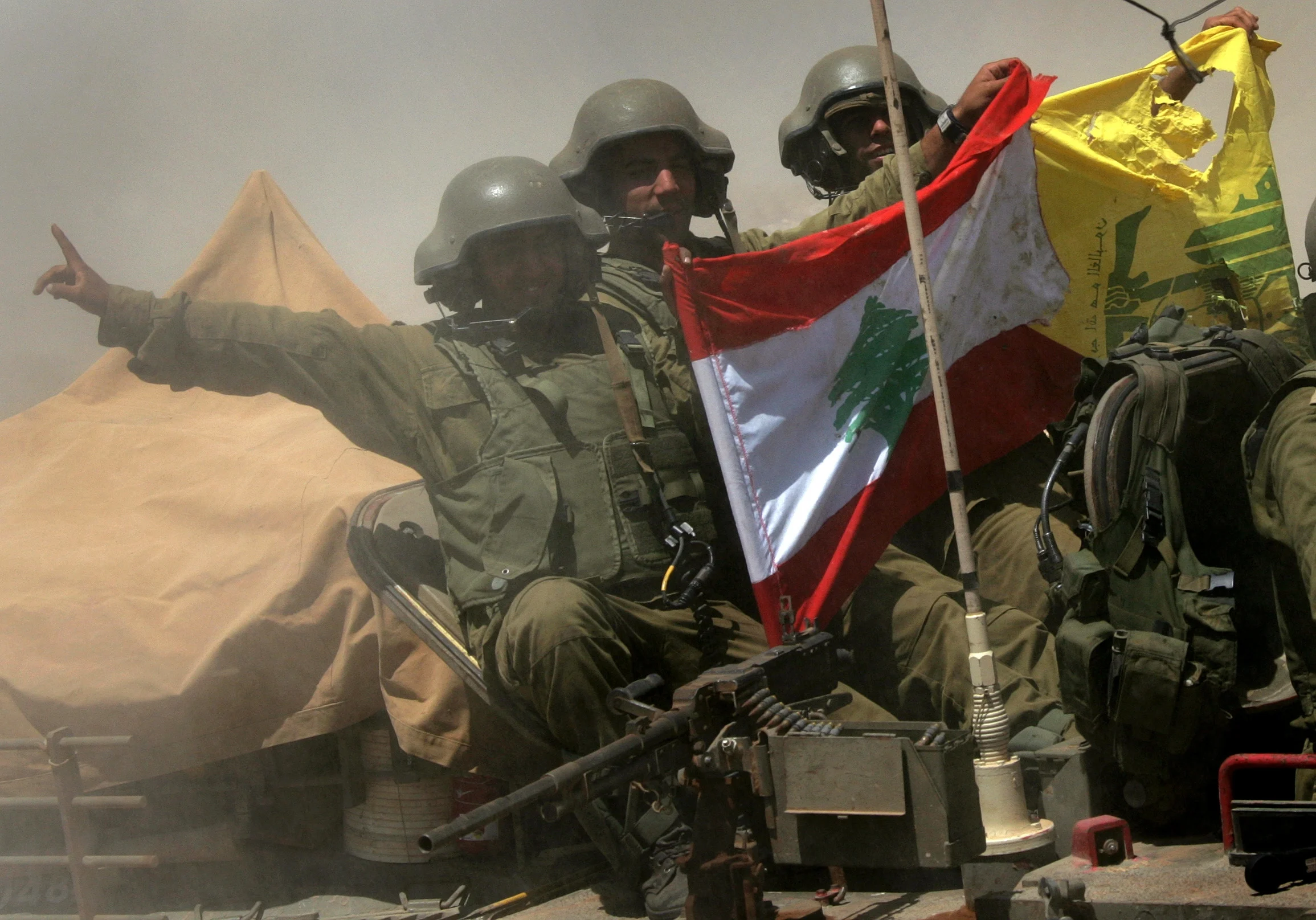 חיילים מחזיקים דגלים של לבנון וחיזבאללה