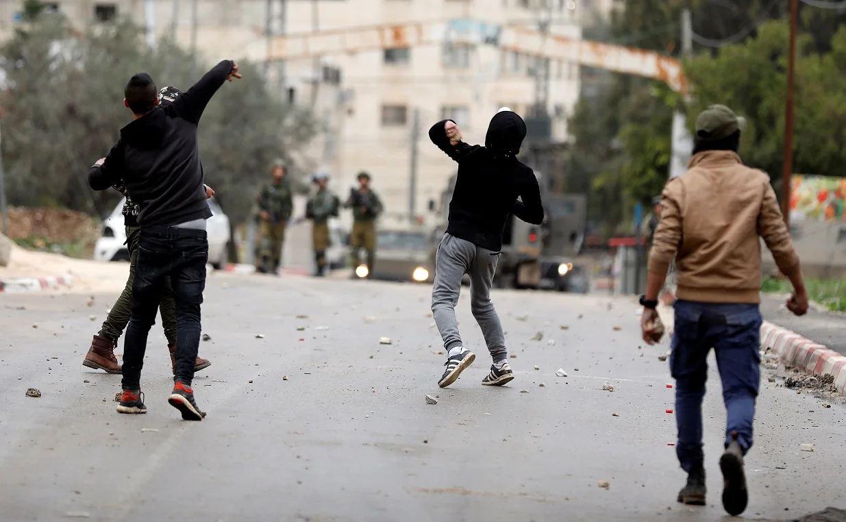 צעירים פלסטינים מיידים אבנים לעבר כוחות הביטחון בעיר ג'נין, שבגדה המערבית
