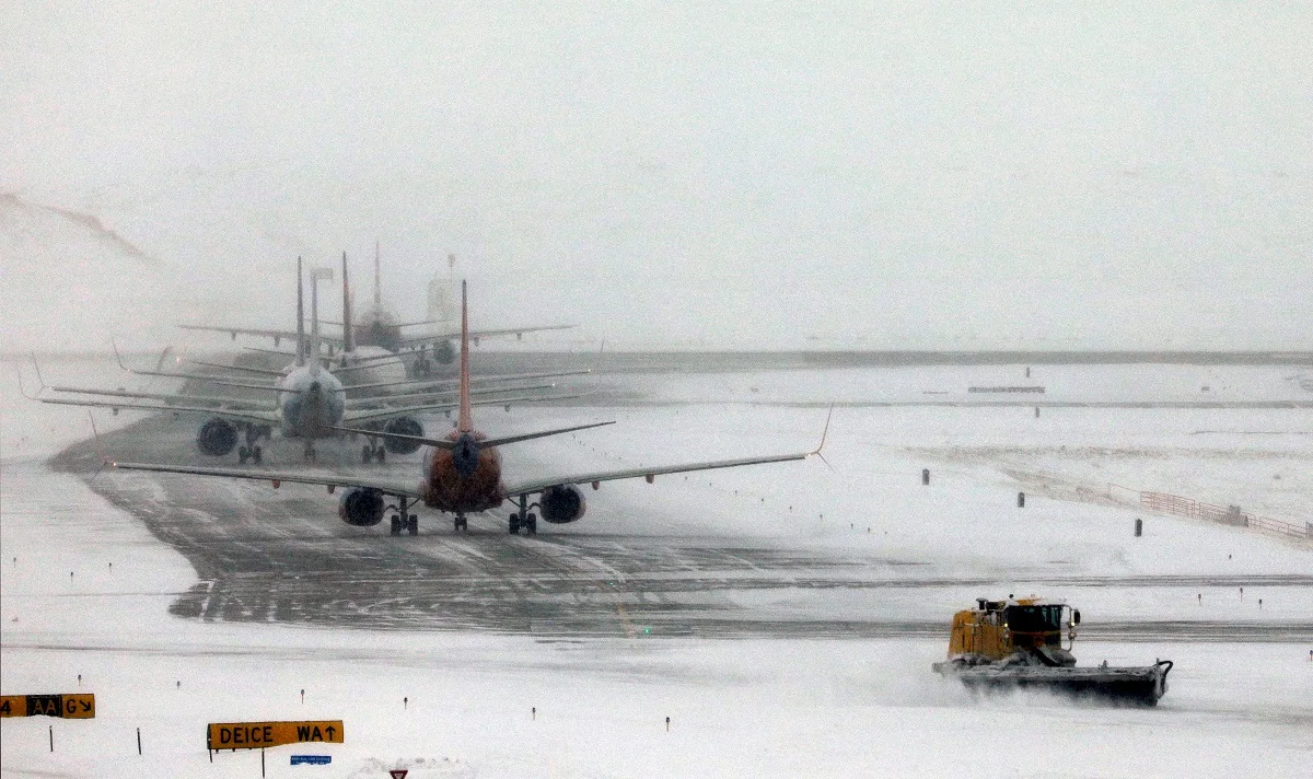 מחרשת שלג מפנה מסלול ליד קו מטוסים הממתין להמראה בשדה התעופה הבינלאומי של דנוור, קולורדו, ארה''ב (ארכיון)