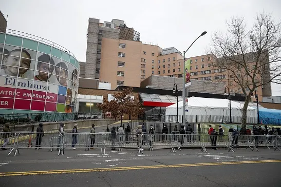 אנשים ממתינים בתור להיבדק למחלת נגיף הקורונה מחוץ למרכז בית חולים אלמהורסט בניו יורק, ארה''ב