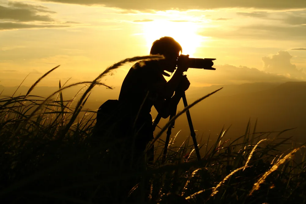 Silhouette,of,a,young,who,like,to,travel,and,photographer,