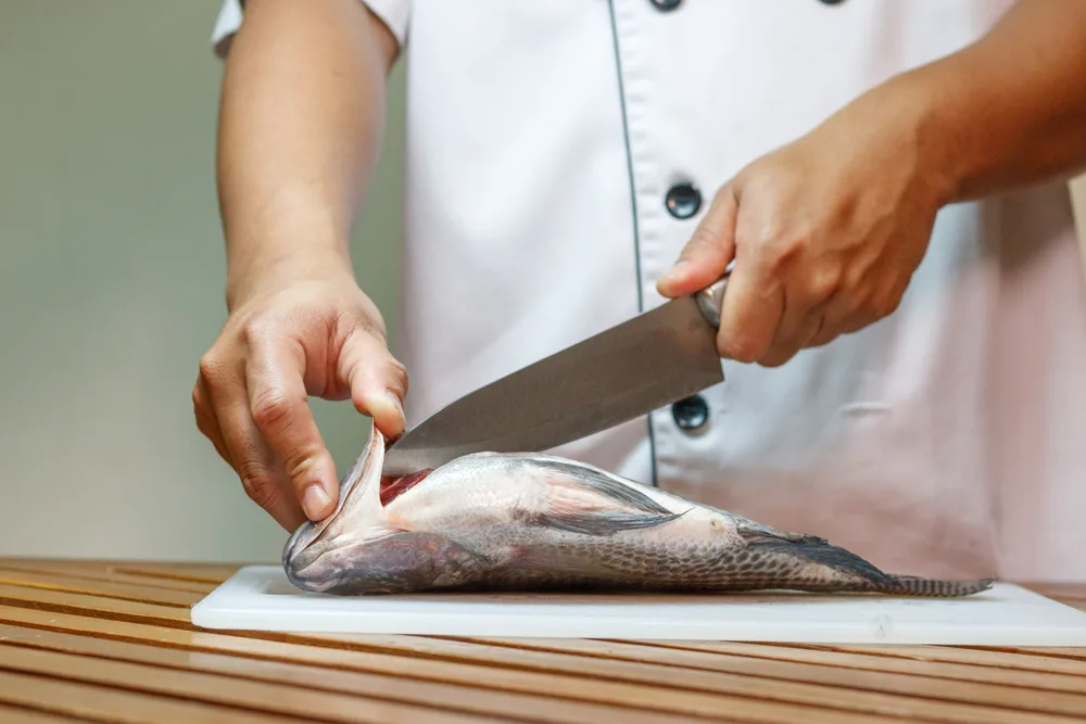 Chef,cutting,fish,in,the,kitchen.