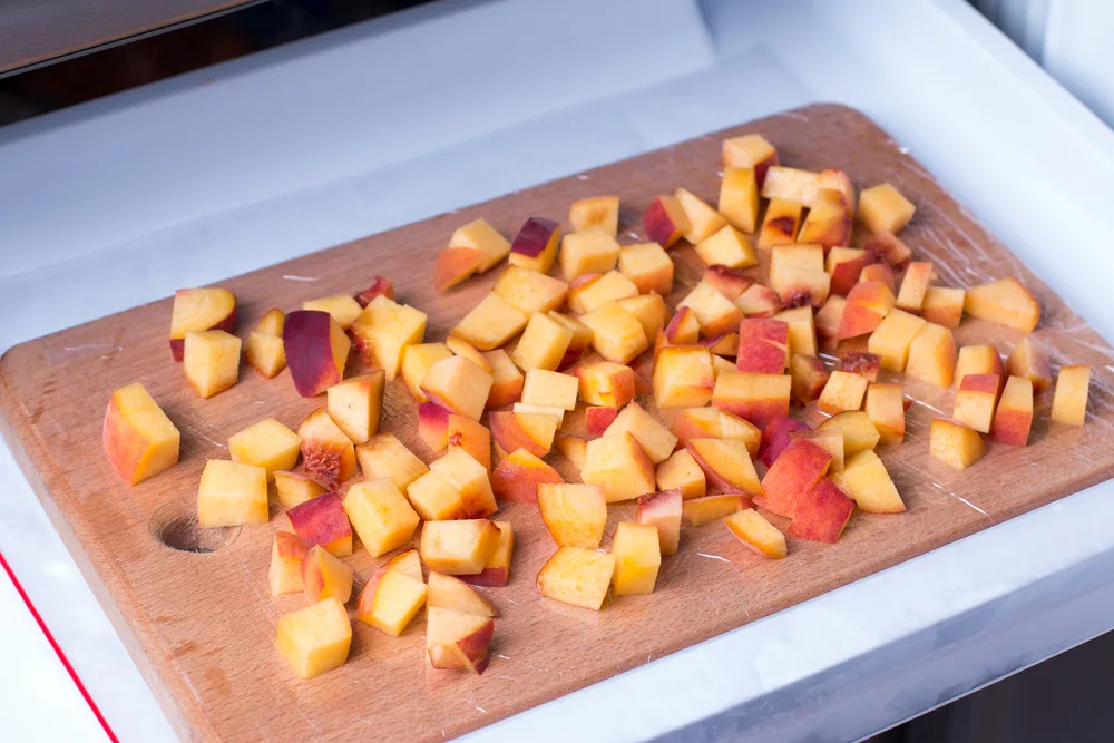 Cubes,of,peaches,on,a,cutting,board,in,a,freezer