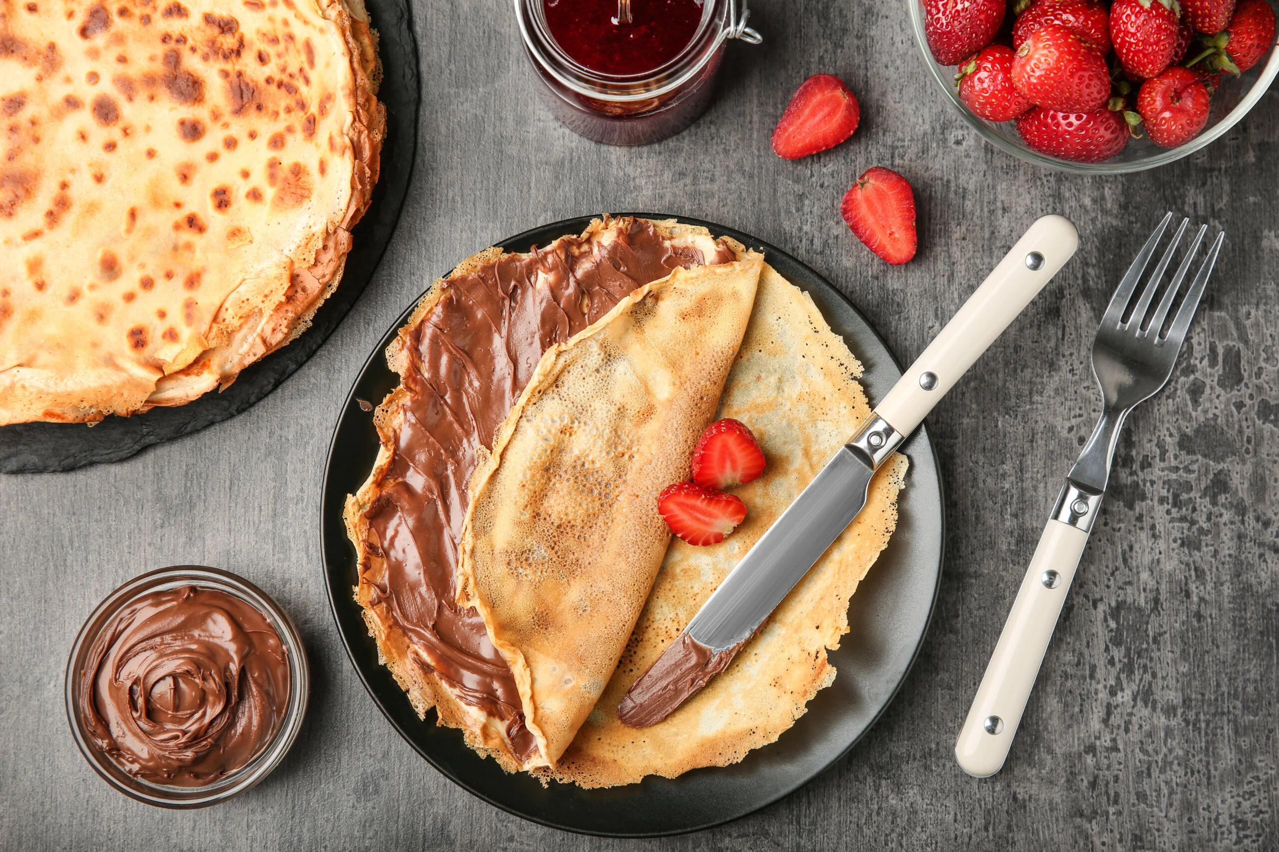 Plate,with,thin,pancakes,with,chocolate,paste,and,berries,on