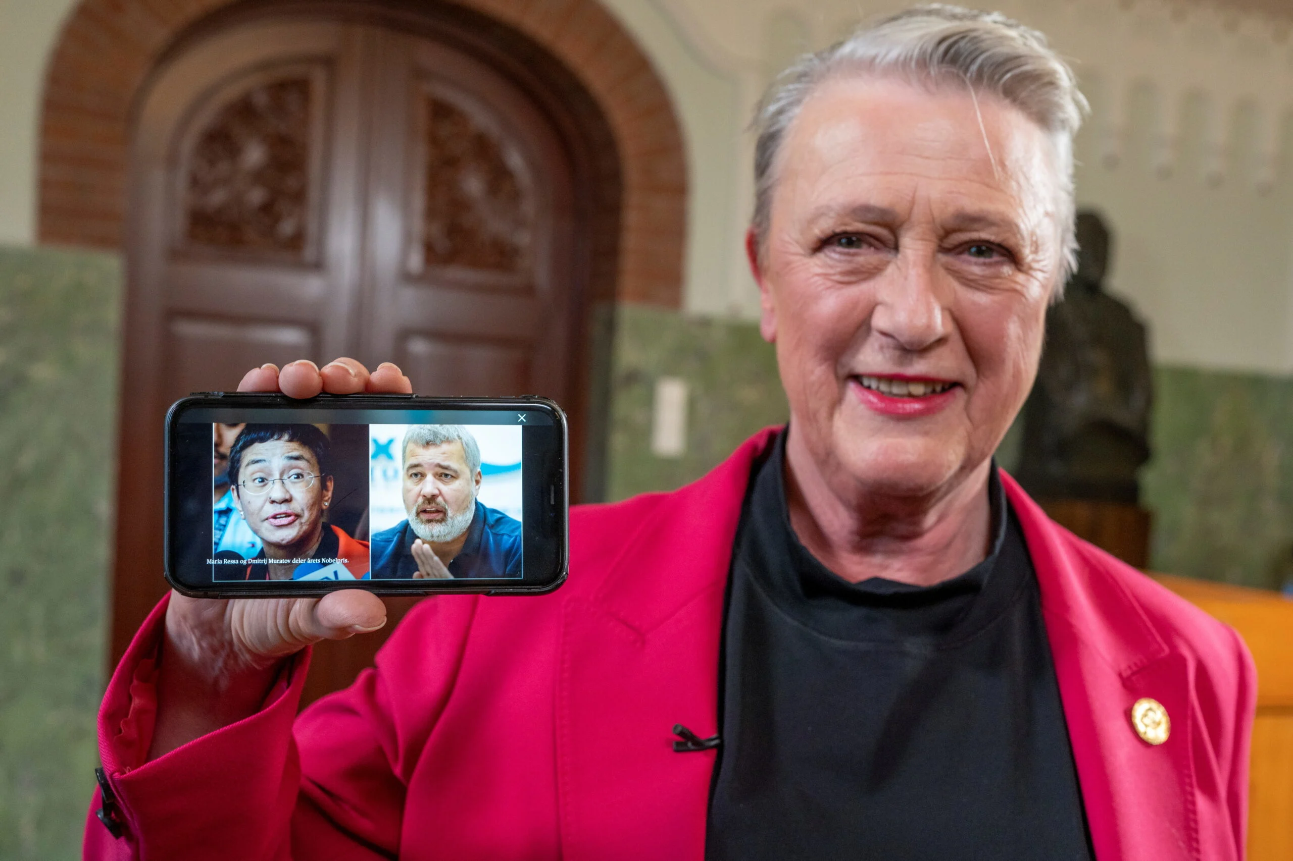יו''ר וועדת פרס הנובל, בריט רייס-אנדרסן מציגה תמונה בטלפון עם שני זוכי פרס הנובל לשלום