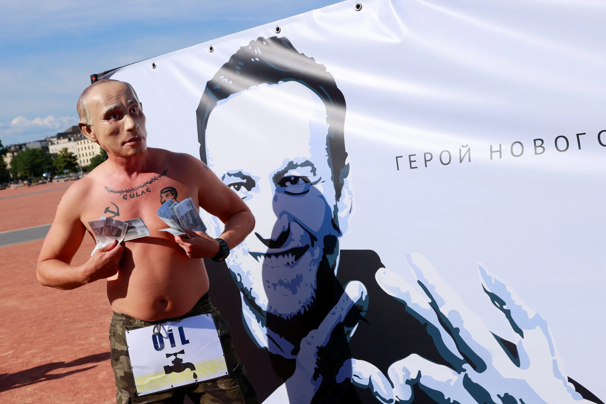 מפגין נגד פוטין בג'נבה על רקע תמונתו של יו''ר האופוזיצה הרוסית הכלוא אלכסיי נבאלני