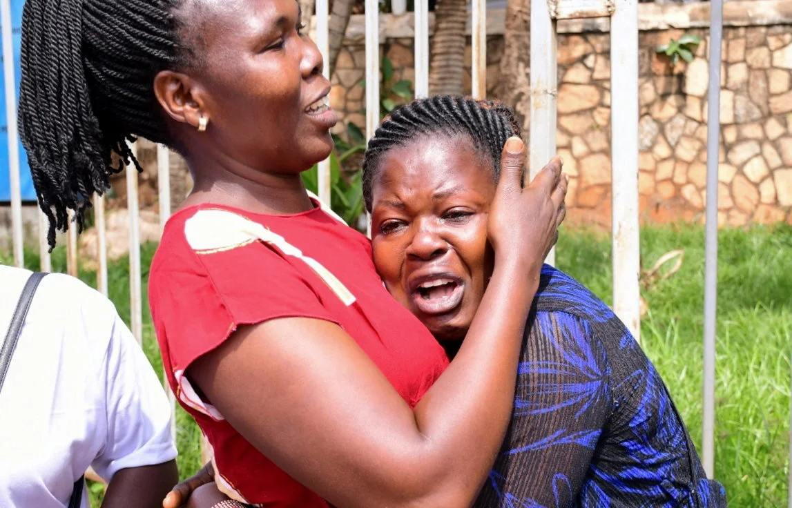A Woman Is Assisted As She Reacts Near The Scene Of A Blast In Kampala