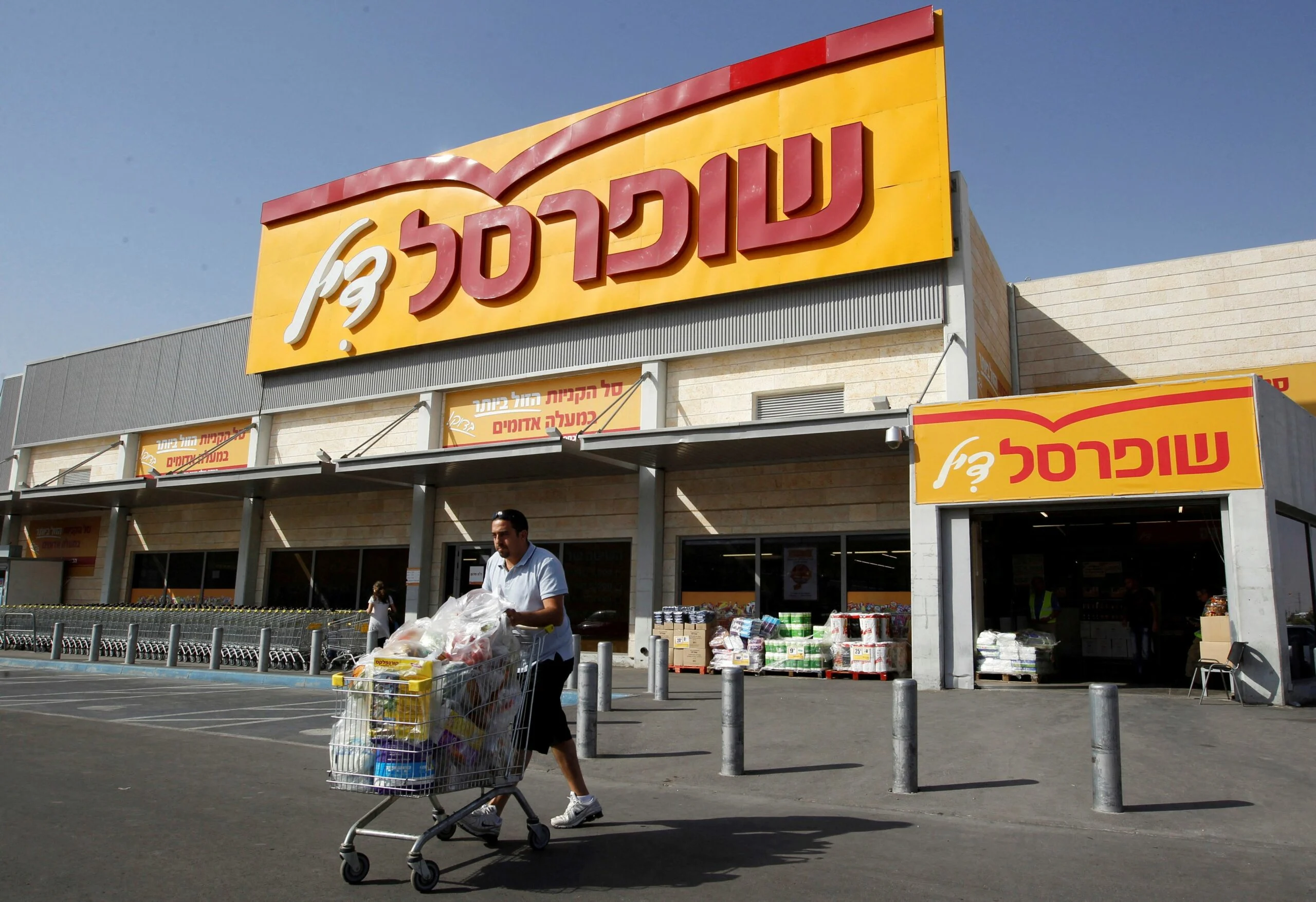 File Photo: A Man Pushes A Shopping Cart Outside Shufersal In The West Bank Jewish Settlement Of Mishor Adumim Near Jerusalem