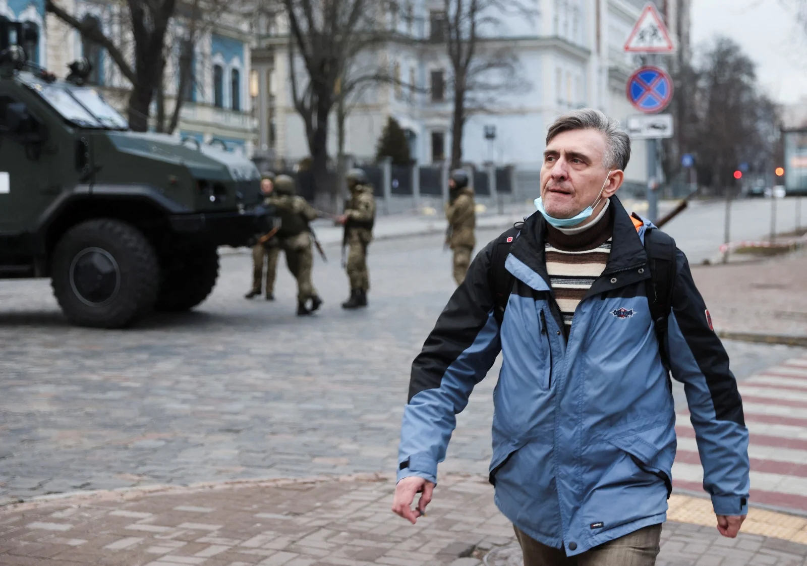 אזרח אוקראיני חולף ליד חיילים ברחובות קייב