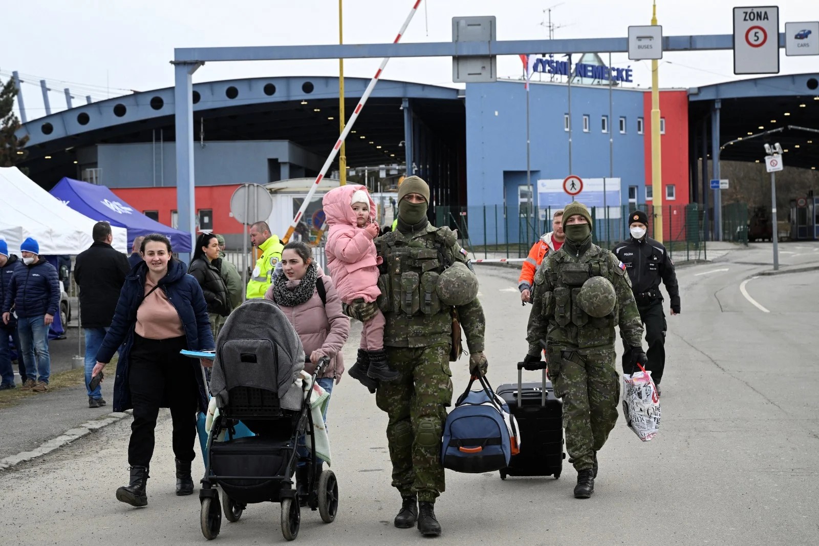 חיילים סלובקים עוזרים לפליטות אוקראיניות בגבול בין המדינות