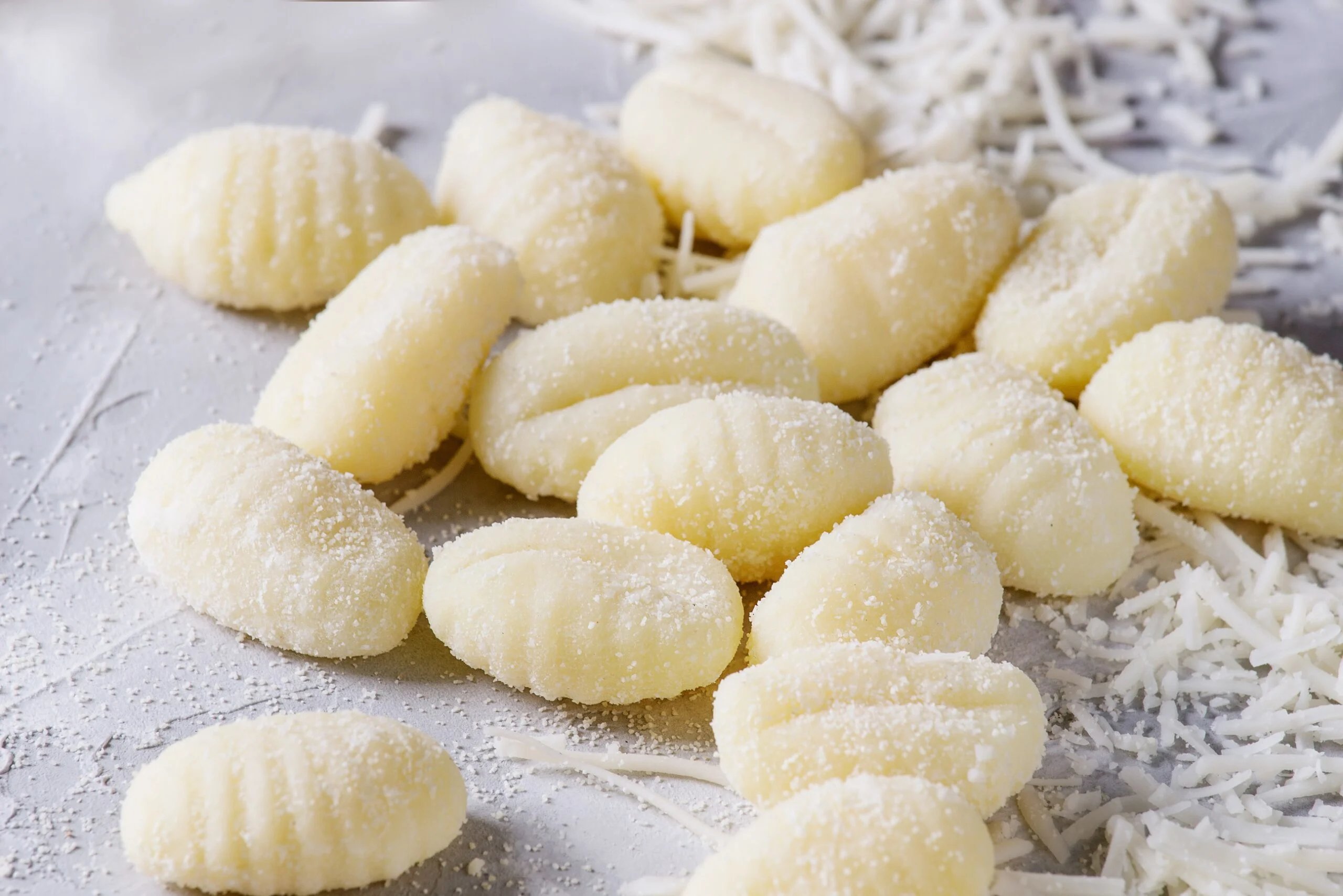 Raw,uncooked,potato,gnocchi,with,flour,and,grated,parmesan,cheese