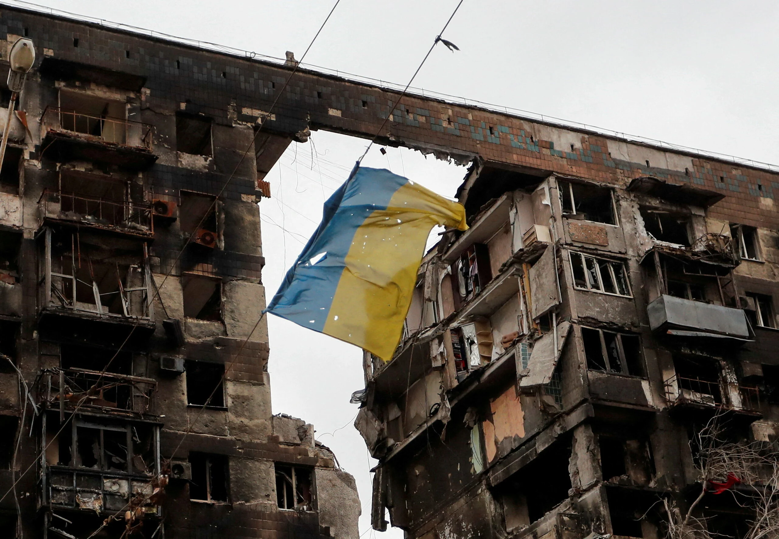 דגל אוקראינה על רקע בניין הרוס במריופול