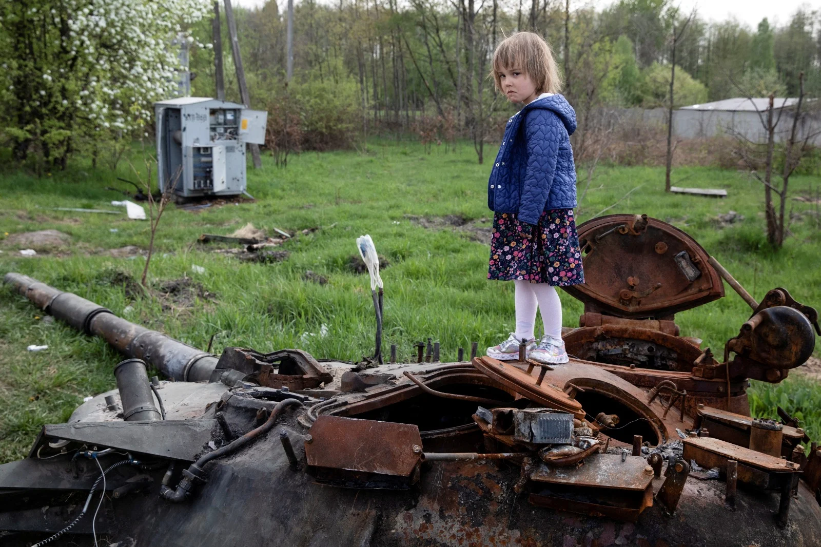 ילדה עומדת על טנק רוסי שרוף סמוך לקייב בירת אוקראינה