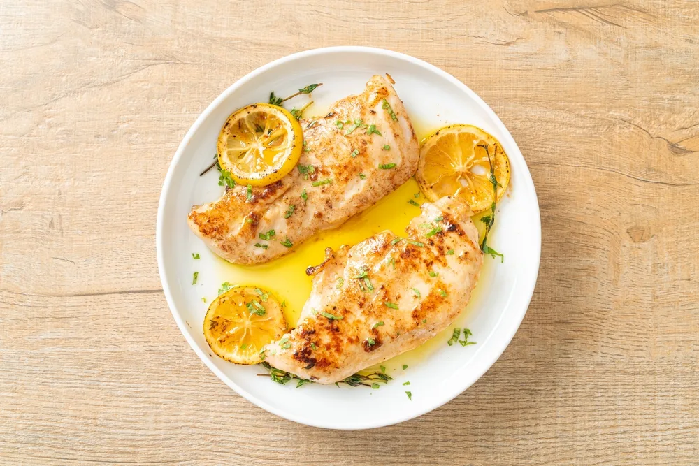 Grilled,chicken,with,butter,,lemon,and,garlic,on,white,plate