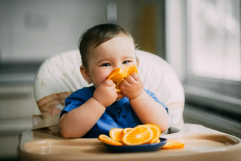 תינוק אוכל תפוזים