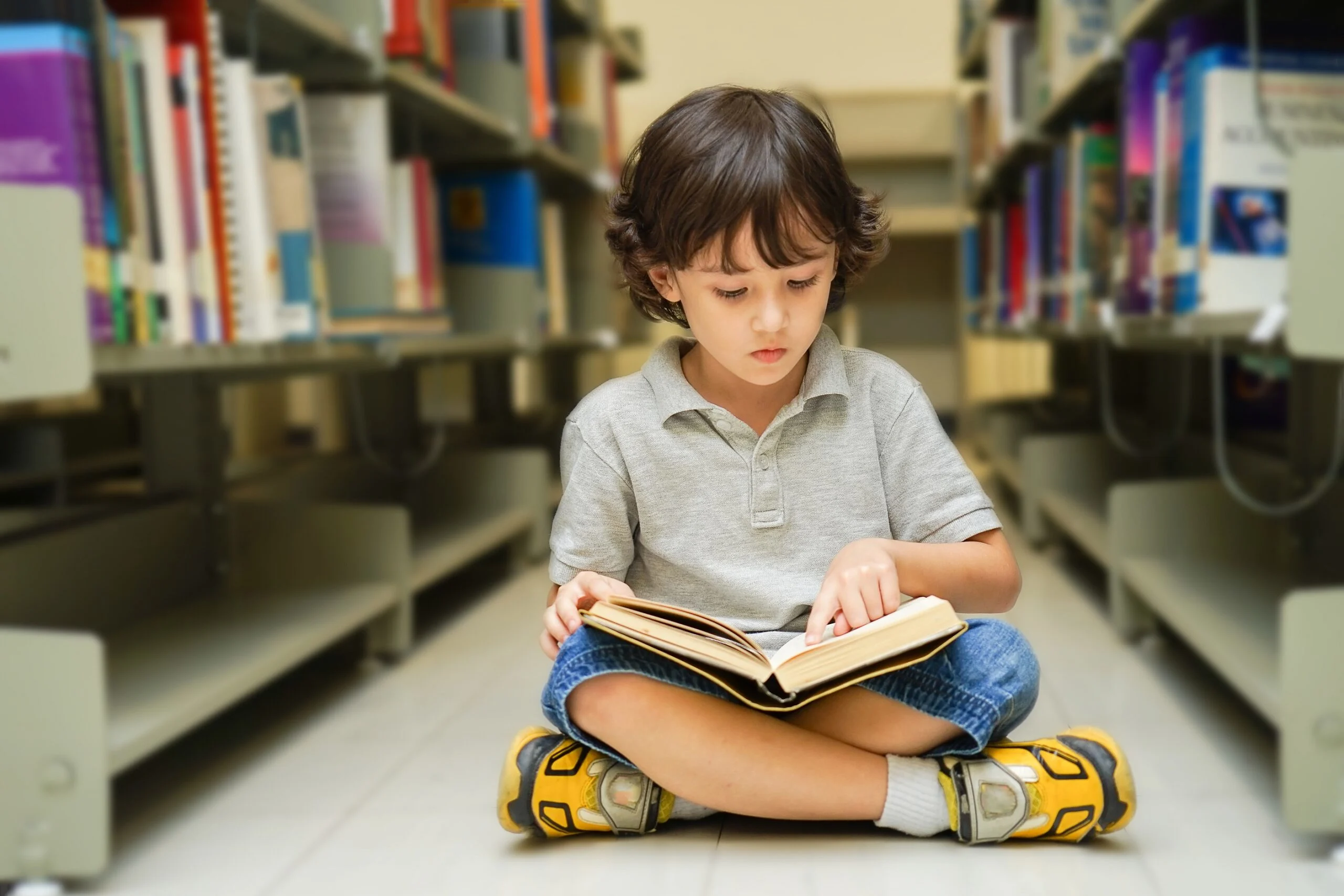 ילד קורא ספר בספרייה